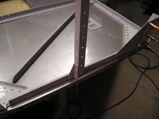 Aux longeron riveted to firewall